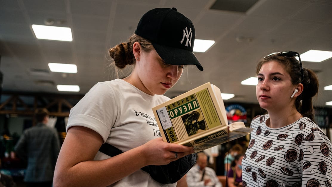 Concerned Russian girls looking at a copy of 1984