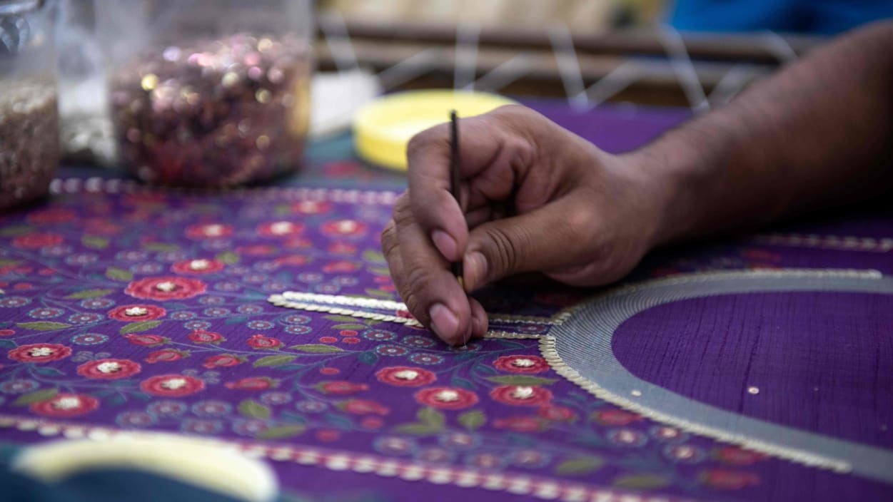 In this photo taken on February 14, 2020, a man works on an embroidery at the factory of fashion deisgner Anita Dongre on the outskirts of Mumbai.