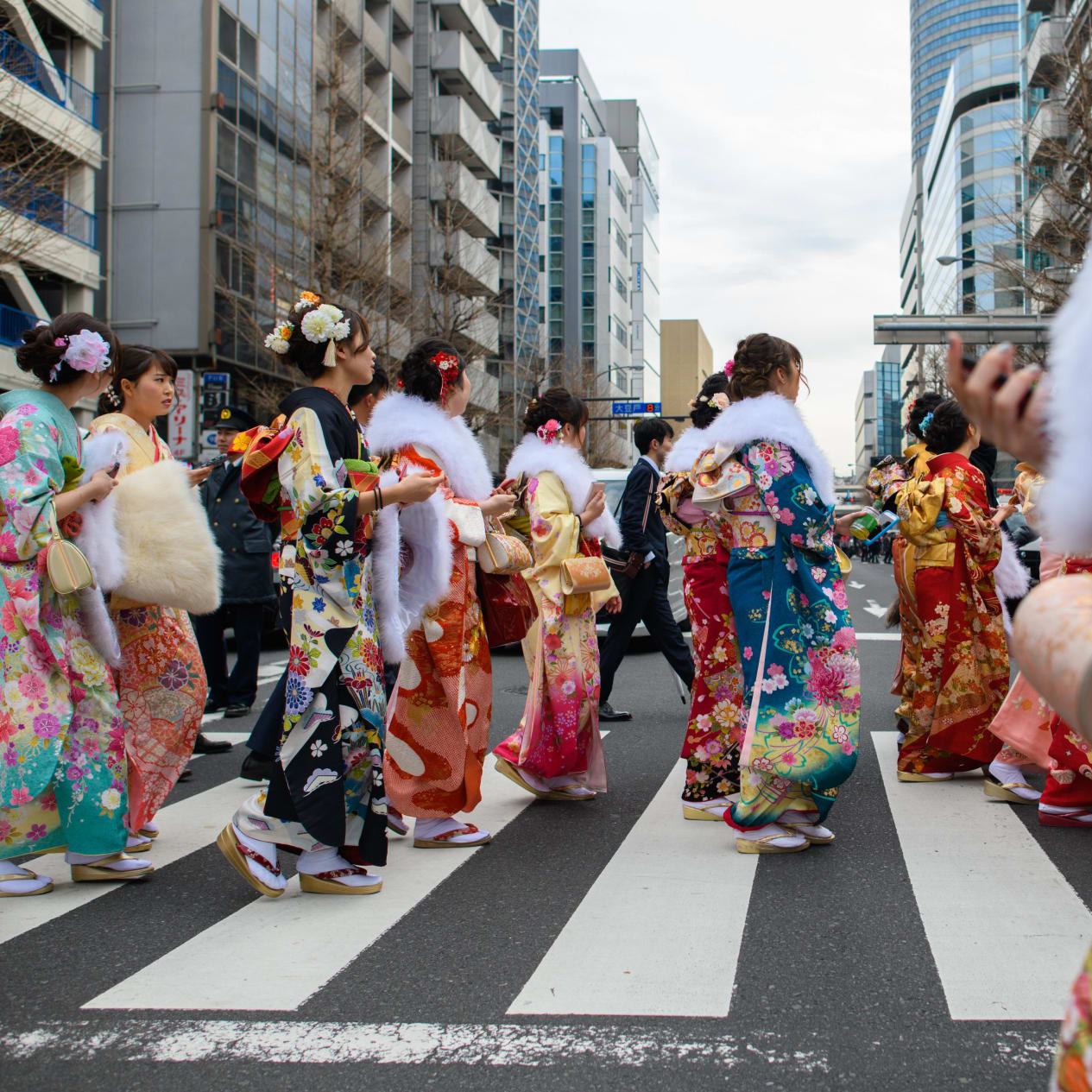 YOKOHAMA, JAPAN - JANUARY 08: Women wearing kimonos cross a road as they le...