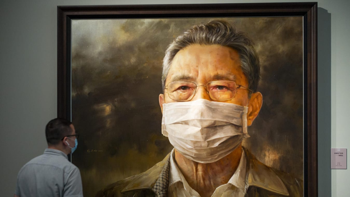 BEIJING, CHINA - AUGUST 04: A visitor looks at a portrait painting depicting Chinese respiratory specialist Zhong Nanshan during an art exhibition on novel coronavirus prevention and control at National Museum of China on August 4, 2020 in Beijing, China. (Photo by Hou Yu/China News Service via Getty Images)