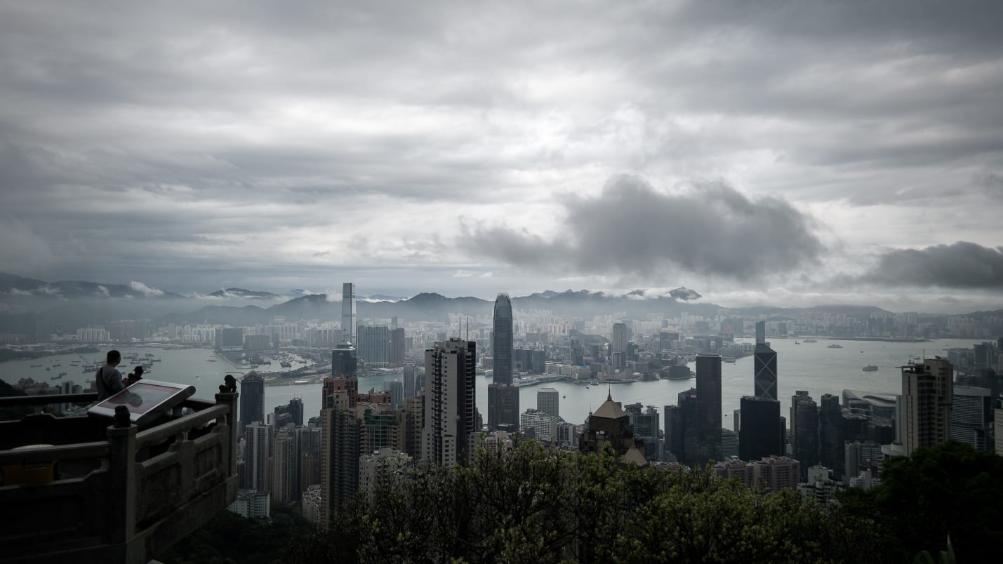 A man (L) looks at the city's skyline as a storm approaches in Hong Kong on April 2, 2014. Stormy weather is affecting the city due to a trough of low pressure on coastal areas of neighbouring Guangdong province in southern China.