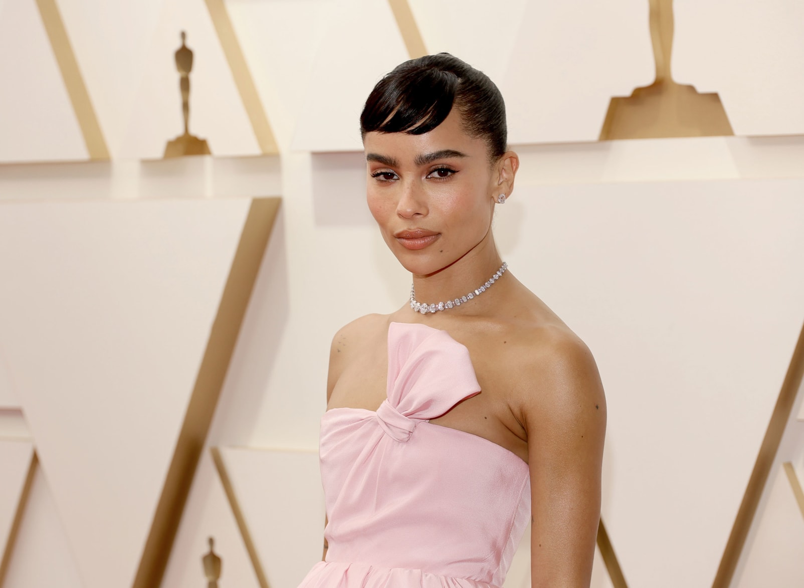"The Batman" star Zoë Kravitz wearing a light pink strapless gown by Yves Saint Laurent and diamond necklace. 
