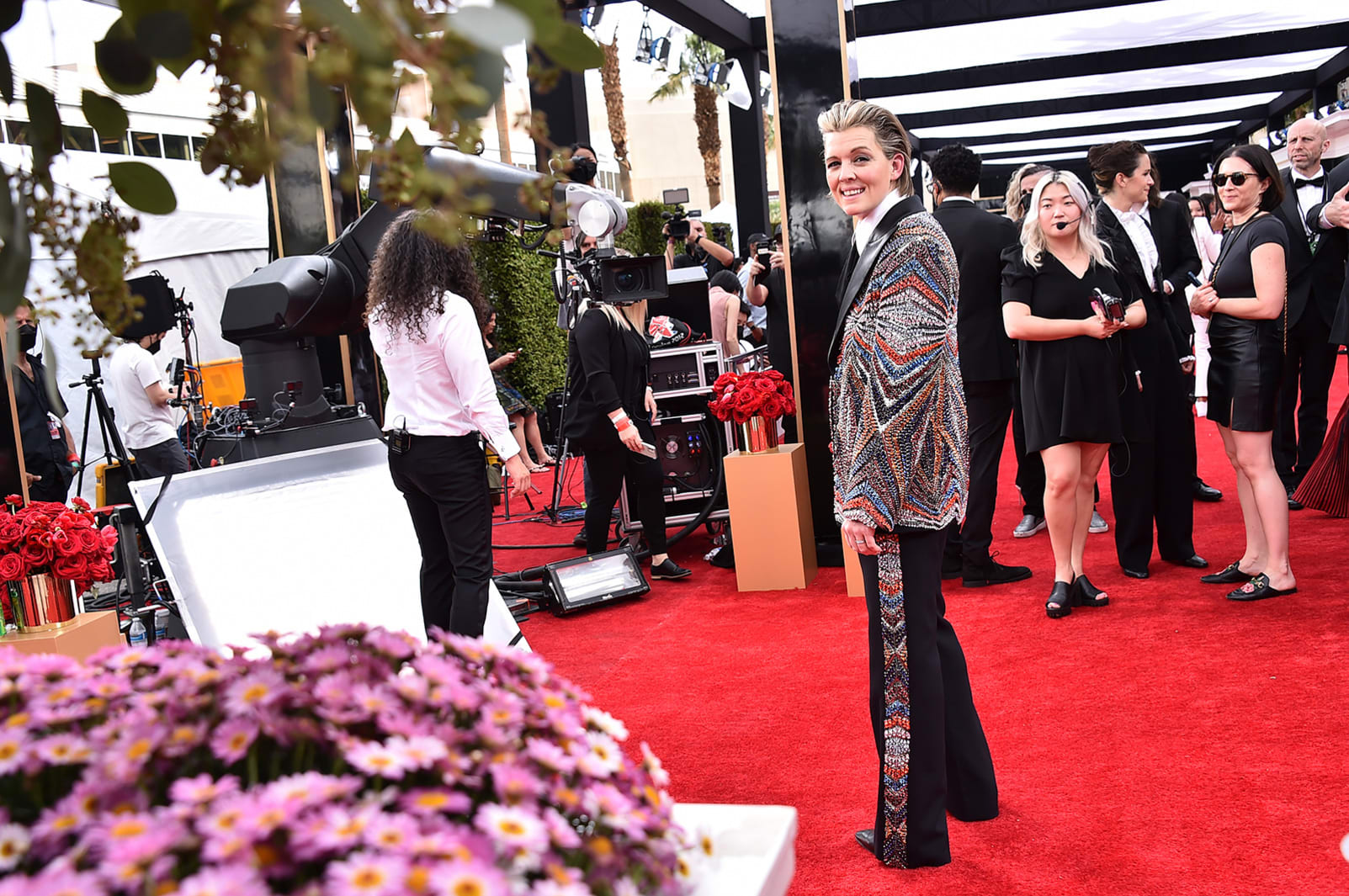 Brandi Carlile walked the red carpet in a multicolored-striped tuxedo adorned with rhinestones and slick-backed hair. 