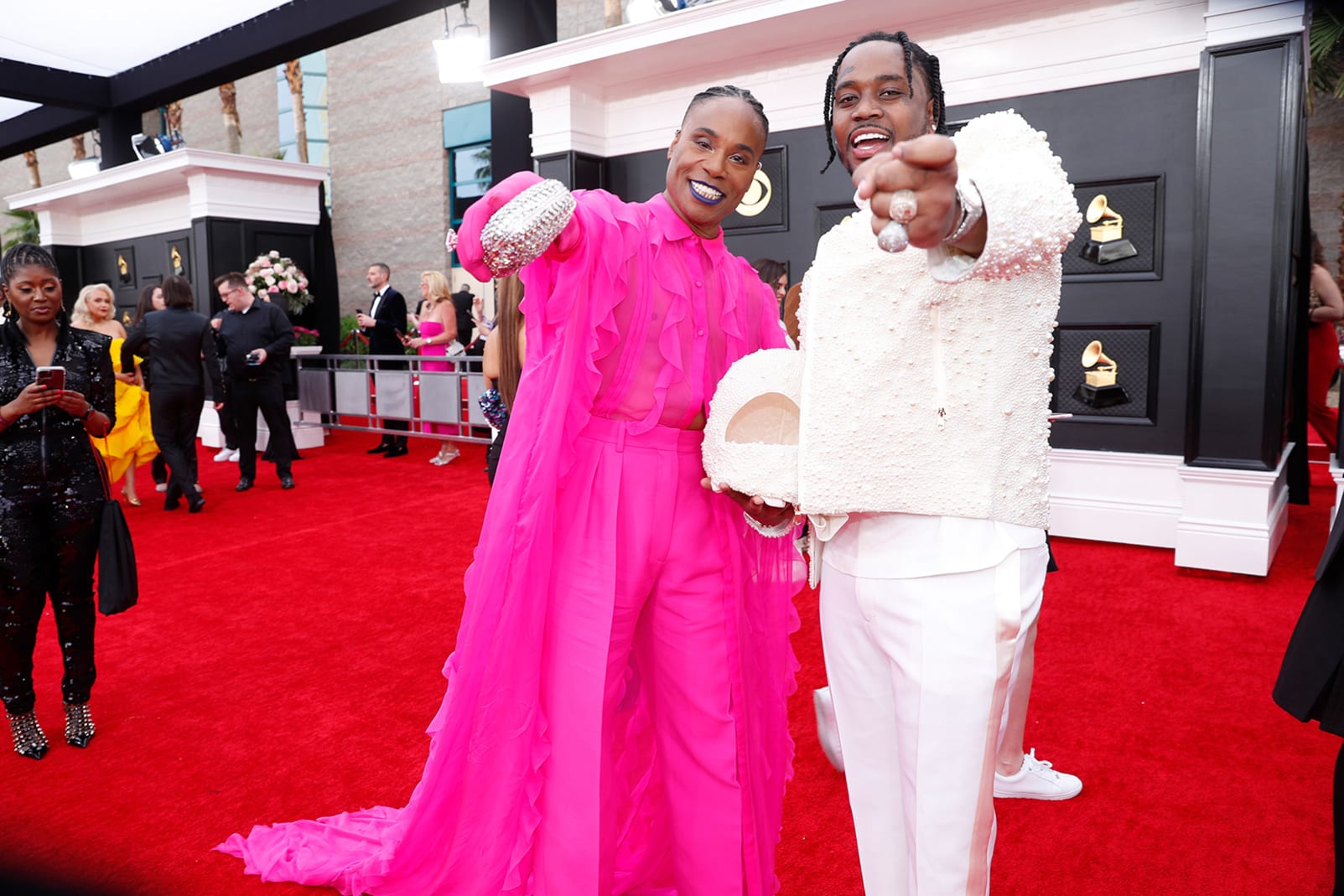 Billy Porter (left) joined the posse of hot-pink looks of the night with a Valentino ensemble that featured a flowing cape, while Fivio Foreign (right) opted for an all-white look with pearls embellishing his jacket and cowboy hat. 