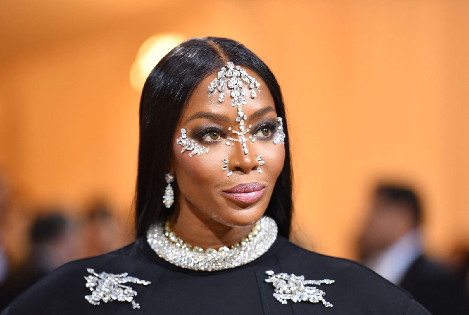 Supermodel Naomi Campbell chose an equestrian-printed custom Burberry look by Ricardo Tisci for the event, coupled with embellished gloves matched to her dress and face jewels. 