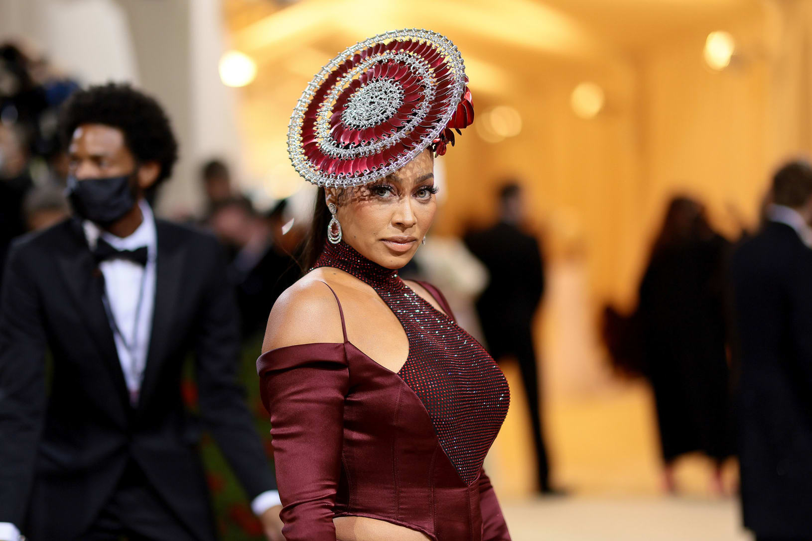 LaLa Anthony arrived in a burgundy high-slit two-piece ensemble by LaQuan Smith with decadent jewelry and intricate headpiece.