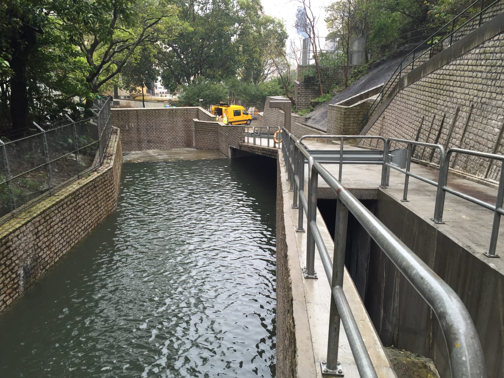 One of the tunnel's intakes, full of rainwater. The water progresses from the intake into the tunnel, instead of inundating the city below. The entrance to the tunnel lies near the middle of the photo, under the life preserver ring. 