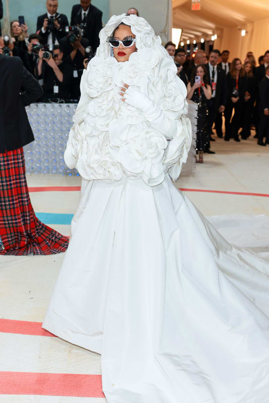 Rihanna's white custom Valentino gown, which she wore with a white floral hooded coat, fit the spirit of the Chanel brides who closed Lagerfeld's couture shows.