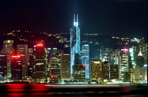 The Victoria Harbor skyline is illuminated by commercial buildings along the waterfront of Hong Kong Island. The Bank of China building, center, designed by Chinese-American architect I.M. Pei to look like an angular bamboo shoot, was completed in 1989. It is one of Hong Kong's most recognized landmarks and a symbol of China's strong economic stake in the territory.  