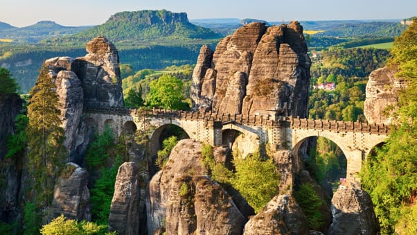 The sun rises over Bastei rocks and the Bastei Bridge in Saxon Switzerland, Germany.