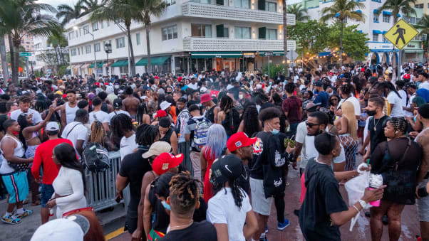 A large crowd of people participate in a party on a walkway near the beach, during spring break in Miami Beach on March 20, 2021