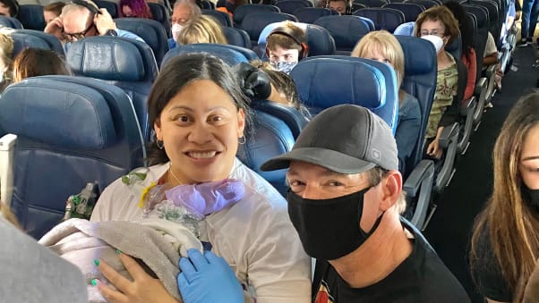 Dr. Glenn poses for a picture with Lavi Mounga and baby Raymond before leaving the plane. 