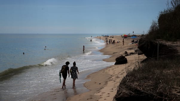 A couple walks the shore at Coast Guard Beach in Eastham on Cape Cod.