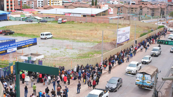 Travelers wait outside the airport in Cuzco on Friday after it was temporarily closed because of protests.
