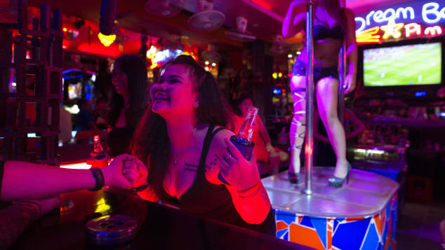 Bar girls entertain men at a bar along the Walking Street in Pattaya, Thailand.