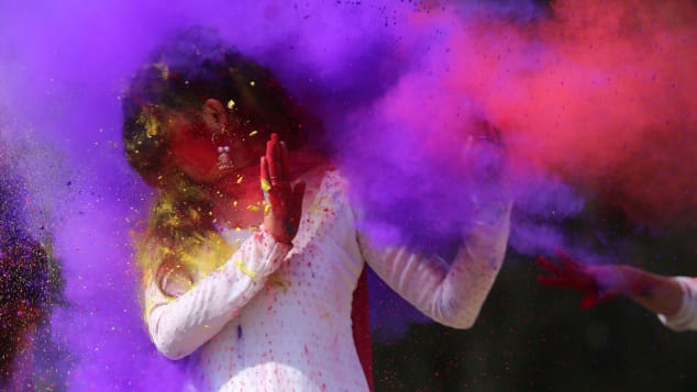 Indian college girls throw colored powder to one another during Holi festival celebrations in Bhopal in 2018. 