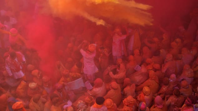 Indian Hindu devotees throw colored powder during celebration of Holi Festival at Sriji temple in Barsana in the northern Indian state of Uttar Pradesh in 2018. 