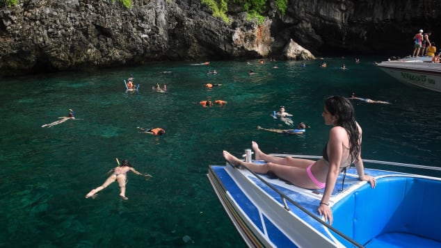 Tourists snorkel in the water near Maya Bay. 