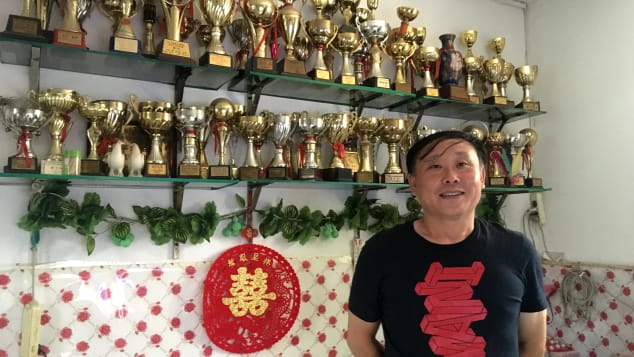 Zhang Jian proudly displays the trophies he has won from pigeon racing