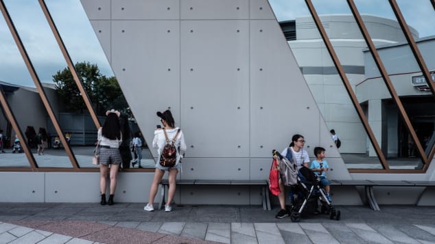 Tourists roam around a quiet Hong Kong Disneyland Resort.