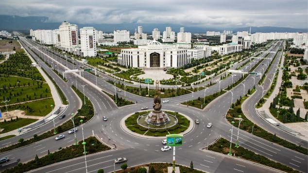 The Dutar monument (front) symbolizes inspiration in Turkmen, with the Turkmen State Institute of Culture in the back. 