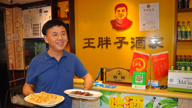 Wang Haibo, regional head of Fat Wang's Donkey Burgers, with a sample of the store's signature products in Beijing in September.
