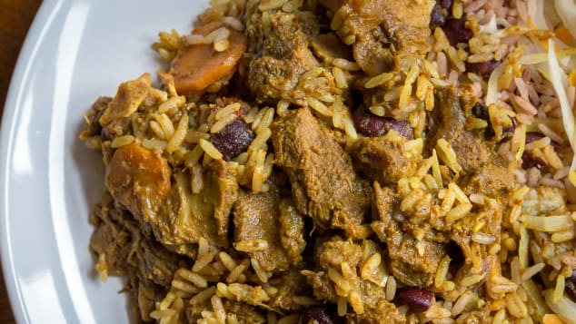 A plate of Jamaican curried goat, served with traditional rice and peas. 