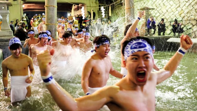 Men in loincloths bathe in cold water to purify their souls as part of the 