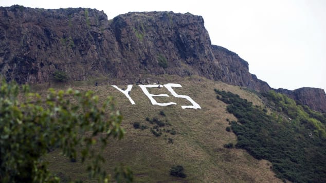 Pro-independence campaigners place a huge "Yes" sign underneath Salisbury Crags in Edinburgh on September 17, 2014, on the eve of Scotland's independence referendum.