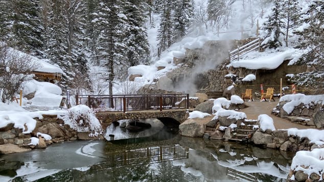 A stone bridge across the icy cold creek leads to the series of hot spring pools.
