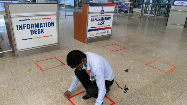 A worker marks squares on the ground at the Rajiv Gandhi International Airport in Hyderabad.