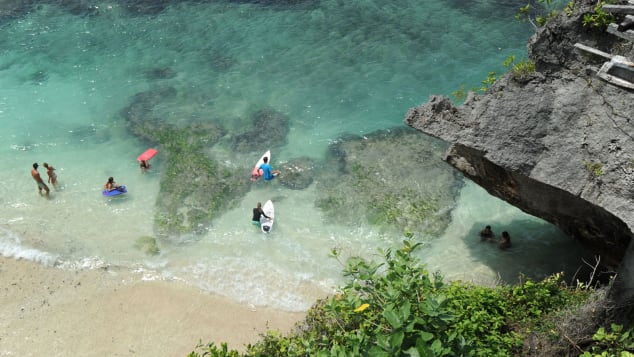 Tourists prepare to surf at Uluwatu beach South Kuta in Badung regency on Bali island, on December 20, 2018