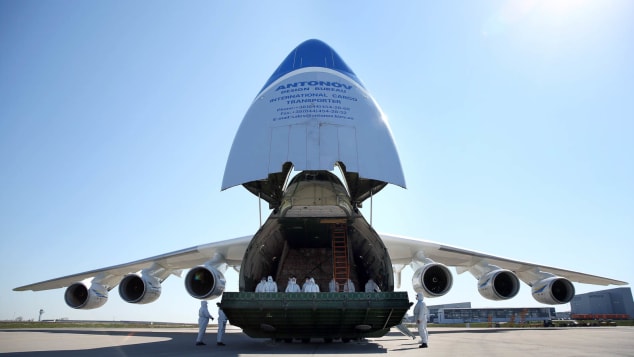 Crew members in protective suits stand inside an Antonov An-225 Mriya cargo aeroplane during a delivery of protective masks from China.