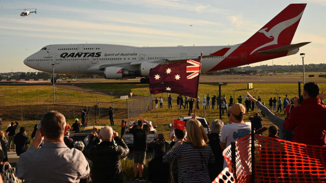 People watch as the last Qantas Boeing 747 airliner prepares to take off from Sydney airport.