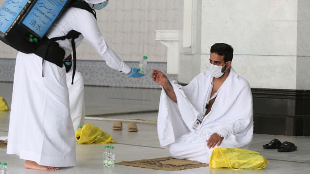 A picture taken on July 29, 2020 shows a pilgrim receiving water at the Grand Mosque complex in the holy city of Mecca.