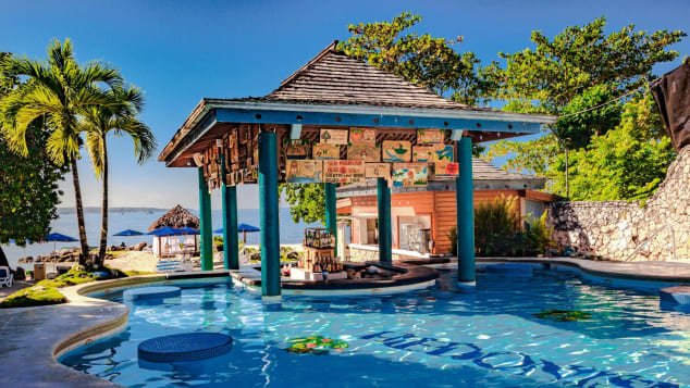 The nude pool, with a swim-up bar, is a central gathering spot for resort guests.