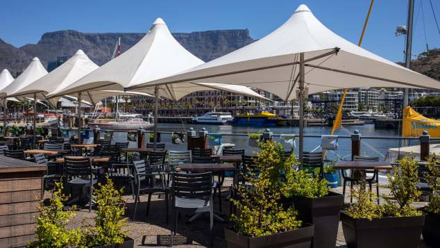 Empty tables at a restaurant terrace area in the Victoria & Alfred Waterfront in Cape Town.