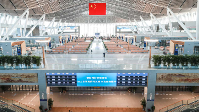 A Chinese flag hangs over an empty departure hall at Beijing Chaoyang Railway Station on the first day of the Spring Festival travel rush on January 28, 2021.