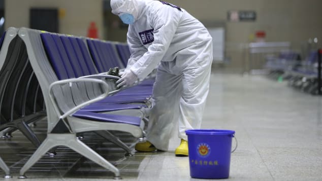 Workers wearing personal protective equipment spray disinfectant at Jingzhou Railway Station in Hubei on Febraury 1, 2021.