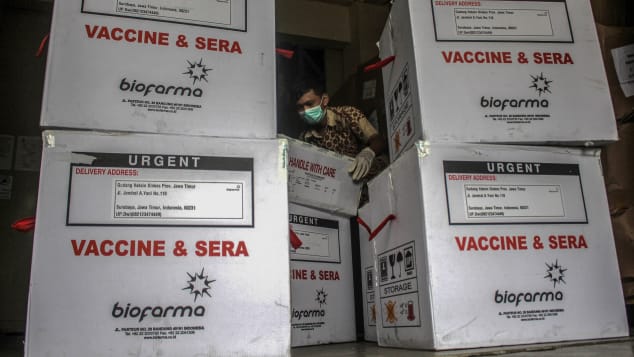 Health authorities officers unload Covid-19 vaccine produced by Sinovac China, under guard from Police at Pharmacy Warehouse in Surabaya, Indonesia on January 13, 2021. 
