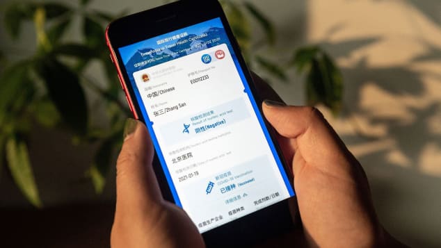 A woman holds a phone displaying a mock-up of Chinas new digital health certificate, the first known implementation of a "virus passport" concept, on March 9, 2021.