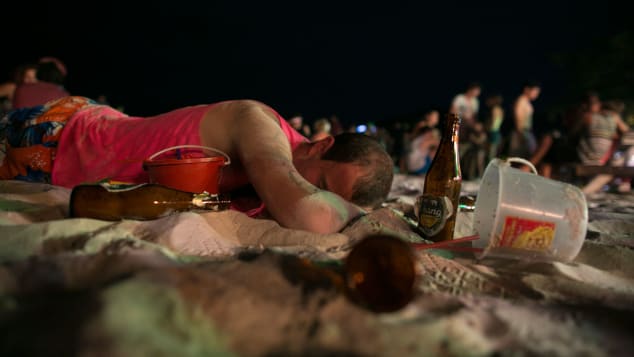 A man sleeps on the beach just before sunrise at the Full Moon Party on Haad Rin beach in 2013. 