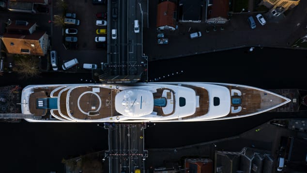 The 94-meter vessel is maneuvered across a bridge in Woubrugge during the tricky journey.