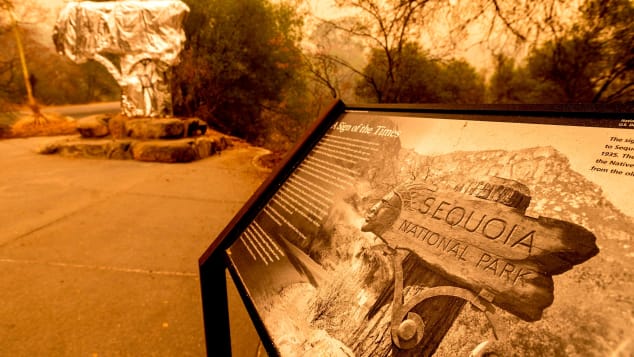A fire-resistant wrap covers a historic welcome sign, as the KNP Complex Fire burns in Sequoia National Park, California, on Sept. 15, 2021. The blaze is burning near the Giant Forest, home to more than 2,000 giant sequoias.