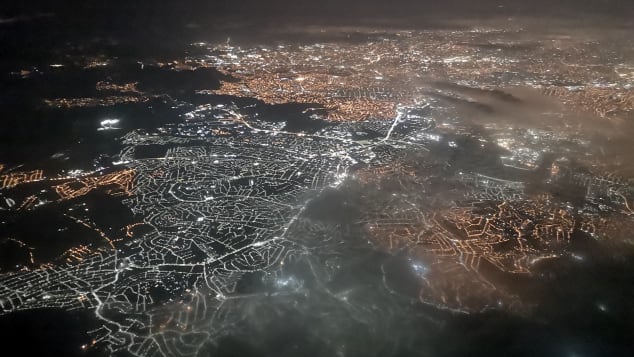 Hipni natën mbi peizazhin e ndritshëm të qytetit të São Paulo. 