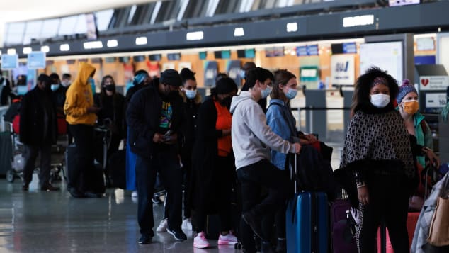 Passengers wait in line to check in for their flights at the Dulles International Airport in Dulles, Virginia, on Monday, December 27. 