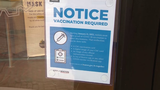 A business in Boston displays a vaccination notice.