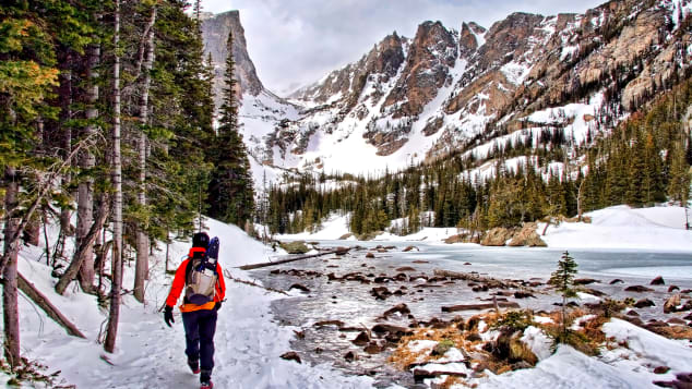 A visitor hikes in a snowy Rocky Mountain National Park in Colorado.