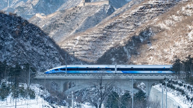 The new Beijing-Zhangjiakou high-speed train travels past the Juyongguan section of the Great Wall on January 25, 2022. 