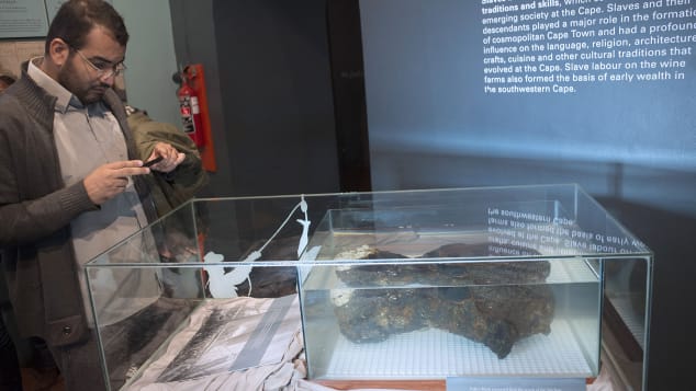 Мужчина фотографирует блок шкивов, один из нескольких найденных артефактов, поднятых из затонувшего Сан-Хосе.